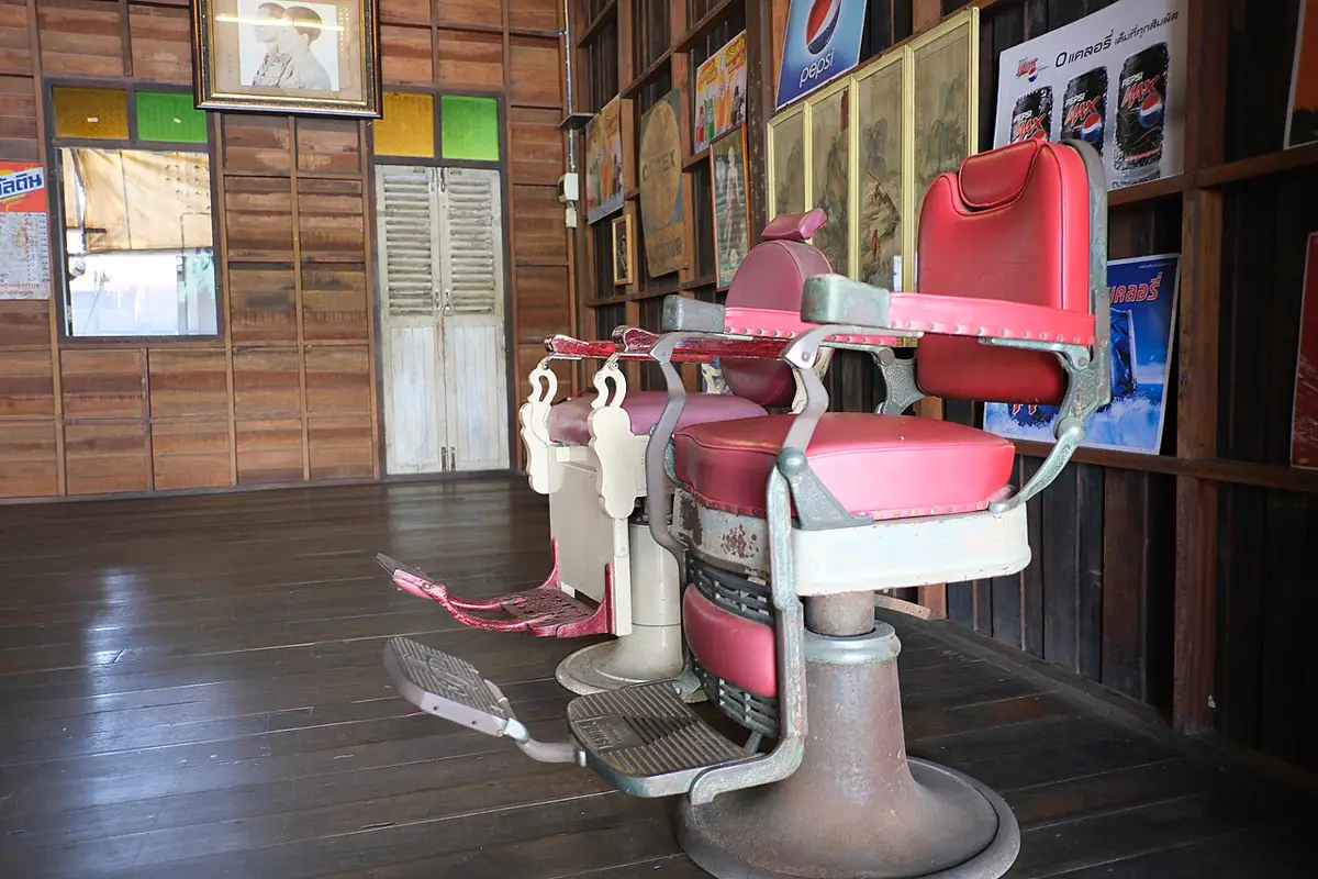 Old red barber chairs in a wooden shop