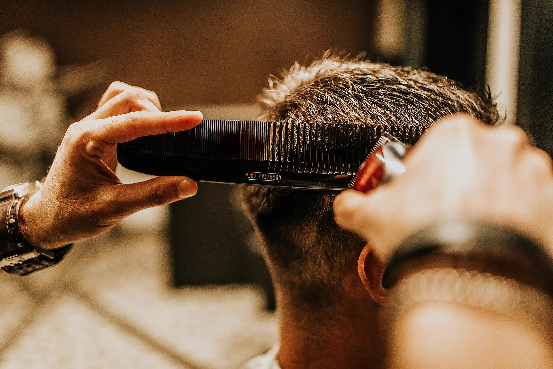 Barbeiro cortando cabelo com tesoura e pente