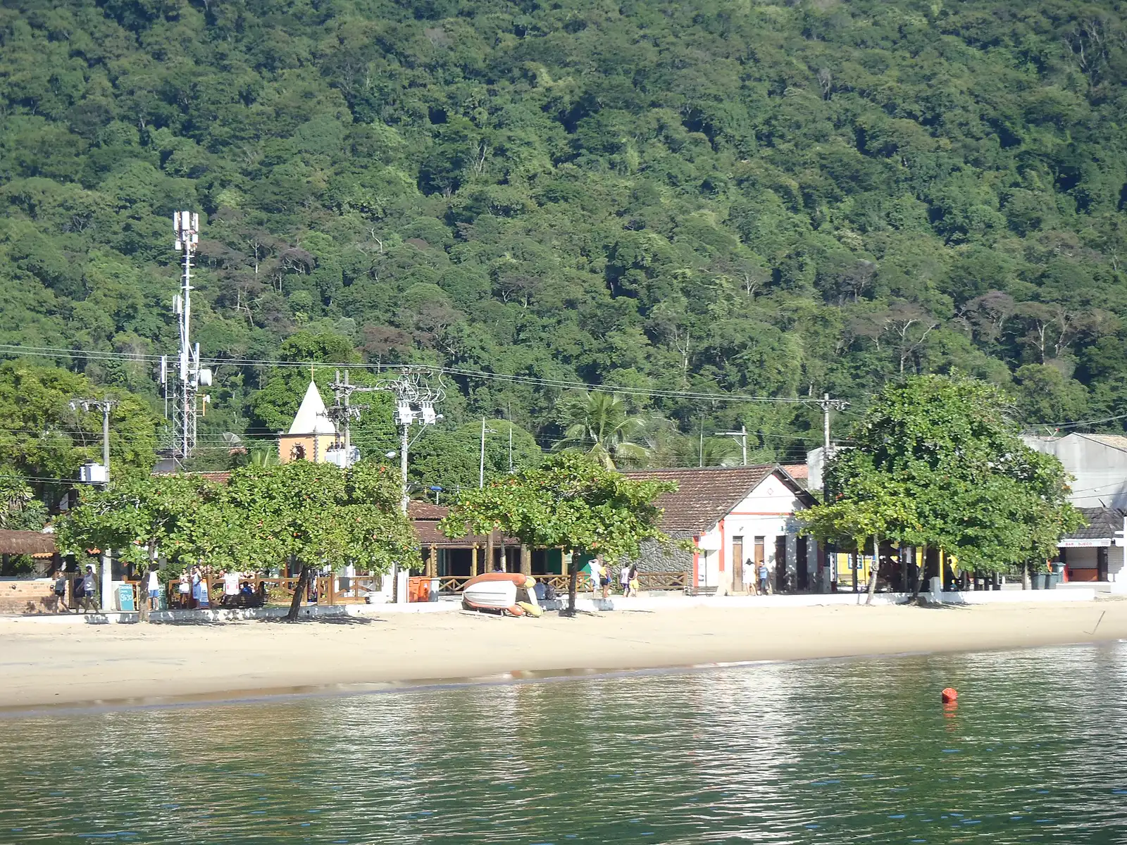 Orla da Vila do Abraão com a igrejinha, as árvores e o morro ao fundo